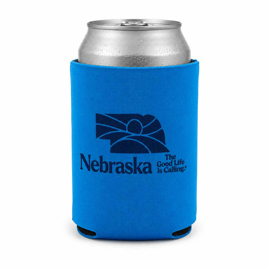 A bright blue neoprene can cooler sleeve with a dark blue Nebraska state graphic and the text 'Nebraska The Good Life is Calling' on a white background, holding a silver aluminum can.