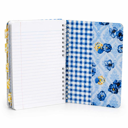 A spiral-bound notebook shown open on a white background, featuring a lined page on the left, a blue-and-white gingham pattern panel in the middle, and a light blue floral pattern panel on the right with blue and yellow flowers.