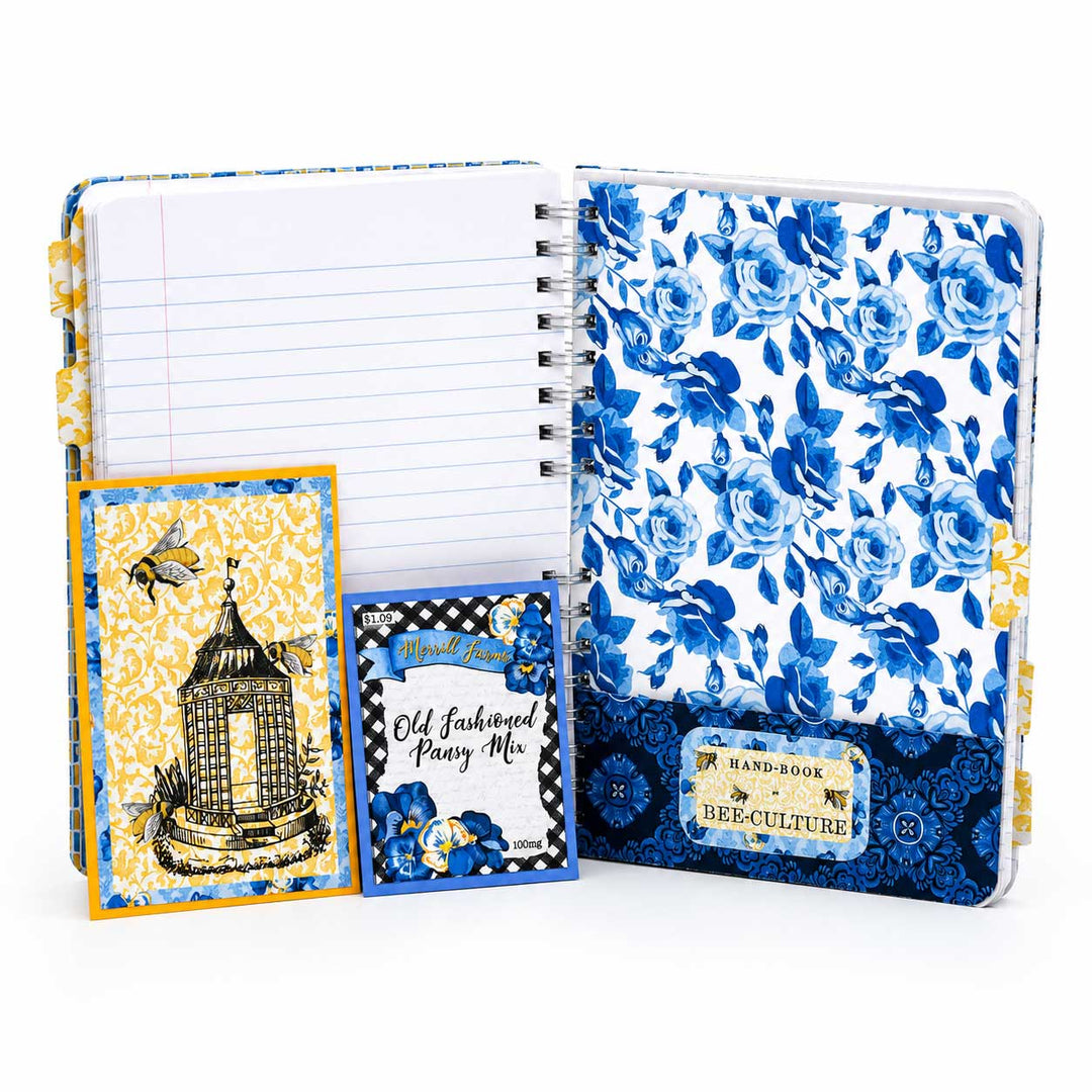 A bee-themed stationery set from Bee-Culture, featuring a spiral-bound lined notebook, a floral planner cover, a decorative card with a birdcage illustration, and a small booklet titled 'Old Fashioned Honey Me,' all in blue, white, and yellow tones.