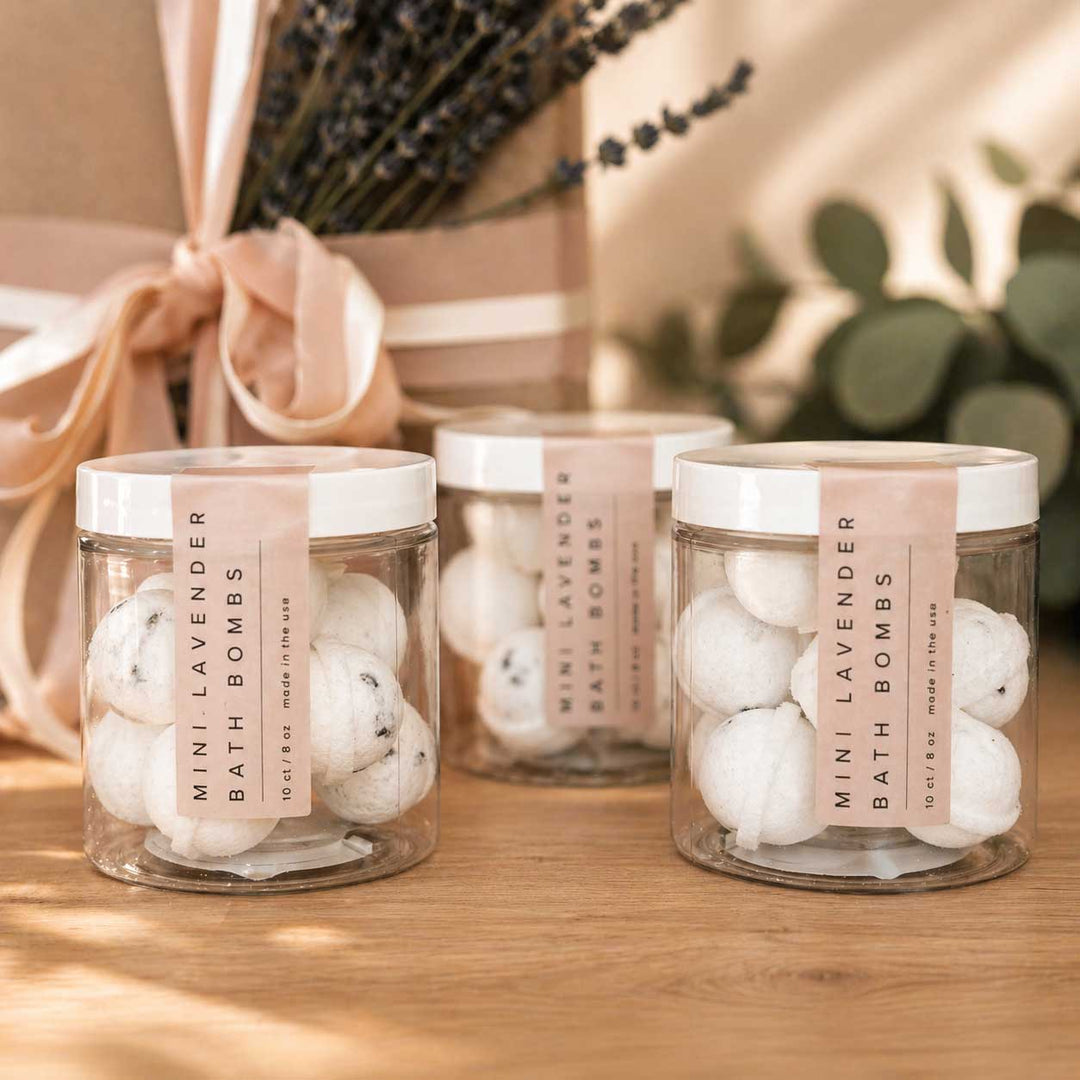 Three jars of Mini Lavender Bath Bombs on a wooden surface with a blurred background