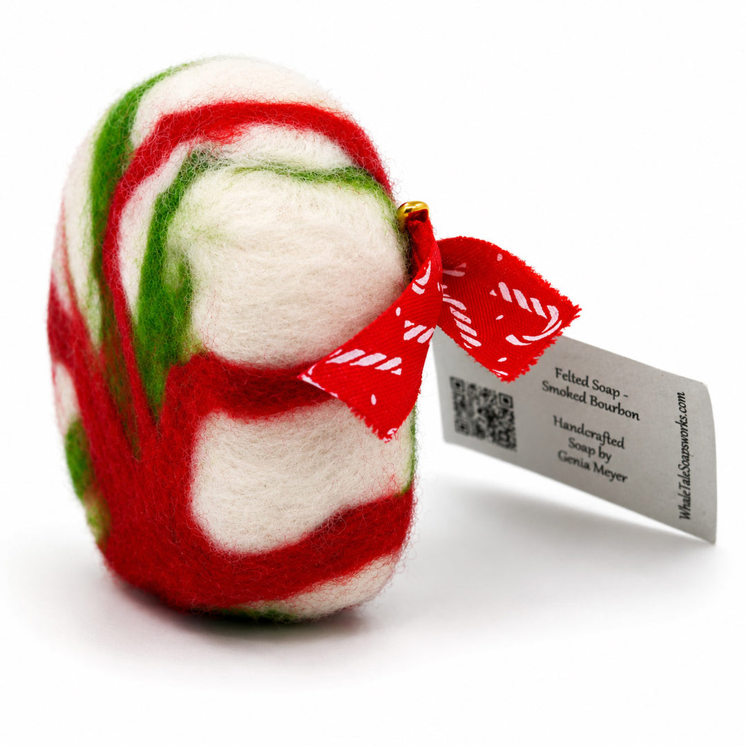 Felted soap with red, green, and white swirls and a tag on a white background