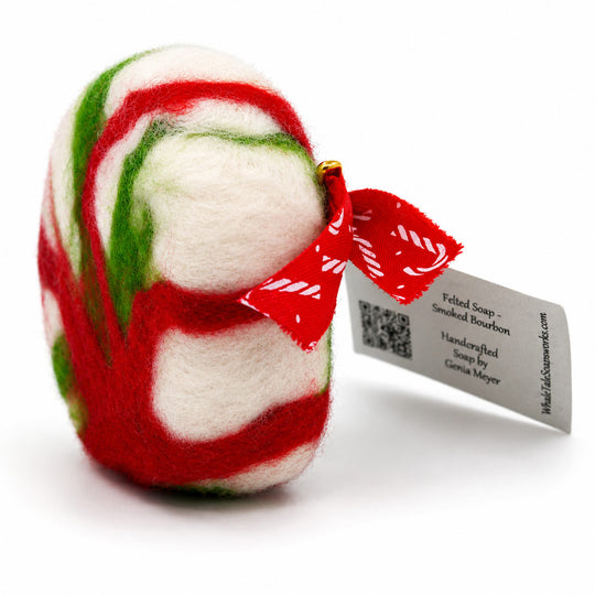 Felted soap with red, green, and white swirls and a tag on a white background