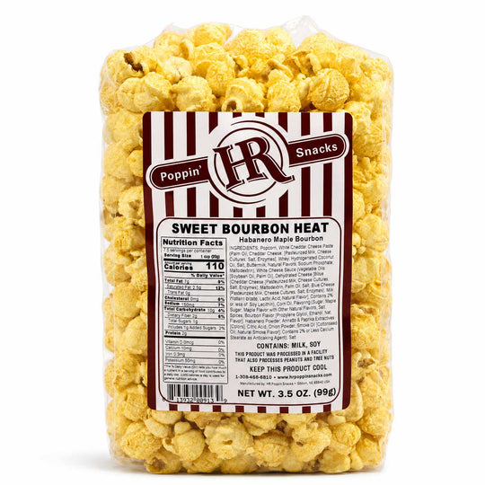 A clear plastic bag filled with yellow popcorn and wrapped in a white and dark red striped label that reads 'Poppin' Snacks' and 'Sweet Bourbon Heat'.