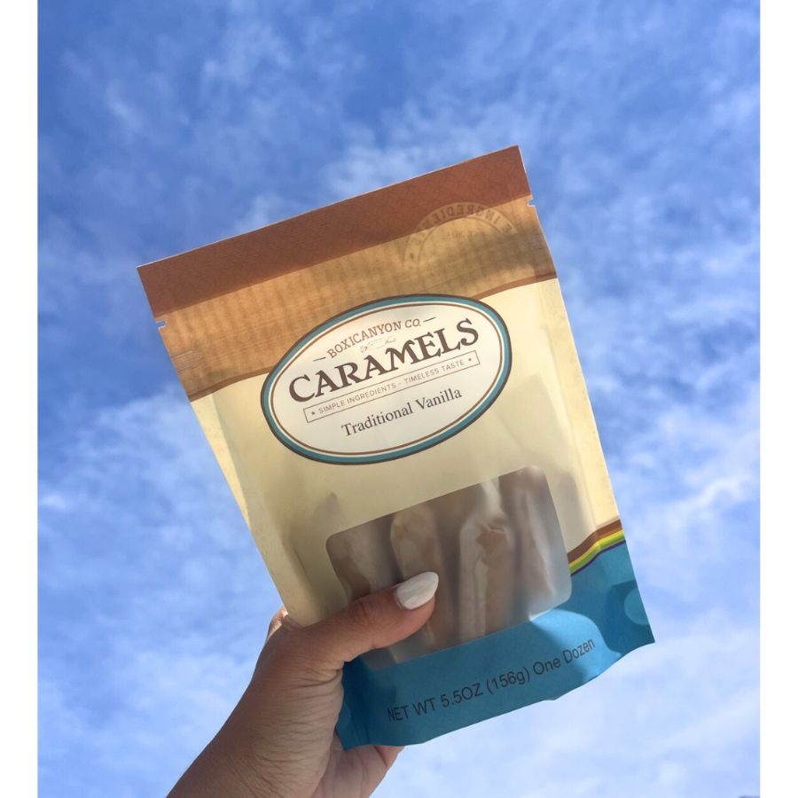 One package of Traditional Vanilla Caramels getting held up to the sky.