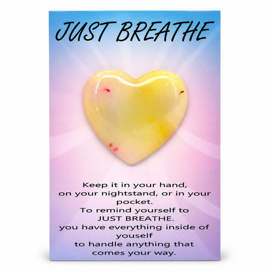 Heart-shaped object with 'Just Breathe' text on a colorful background