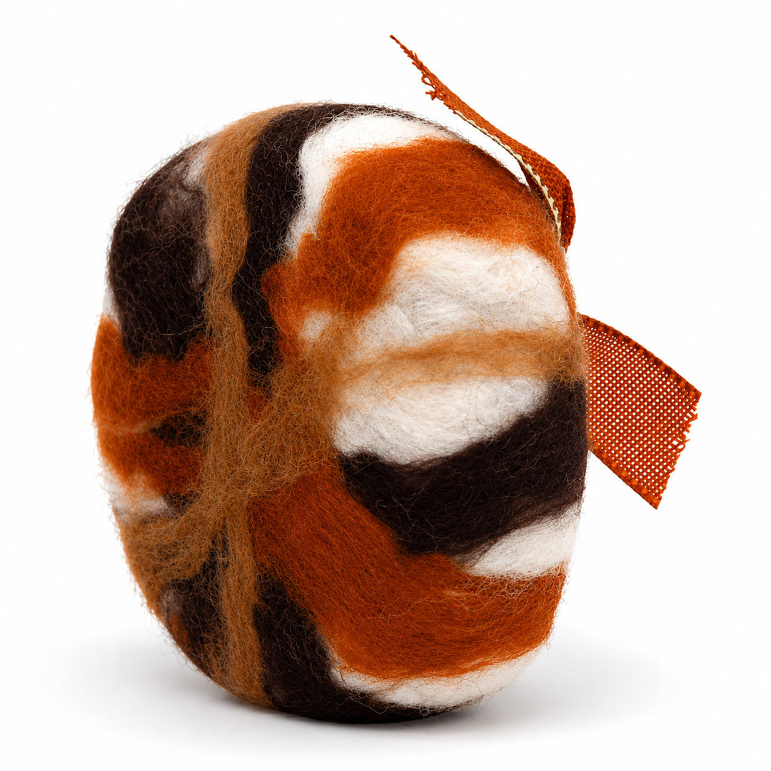 Felted wool ball with brown, orange, and white pattern on a white background
