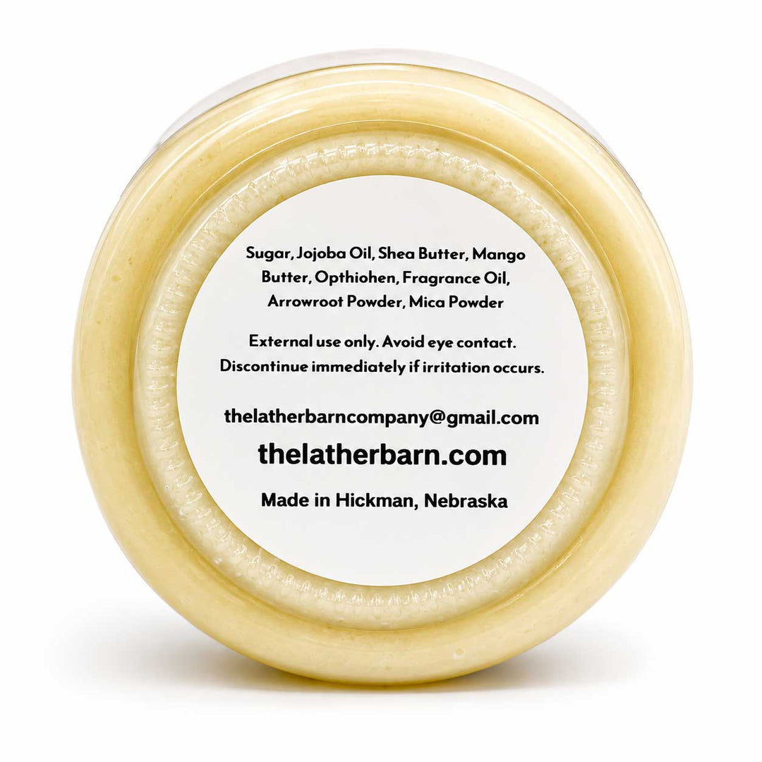 Top-down view of a round beige jar with a white label, showing product ingredients and the brand name 'The Leather Barn Company' on a white background.