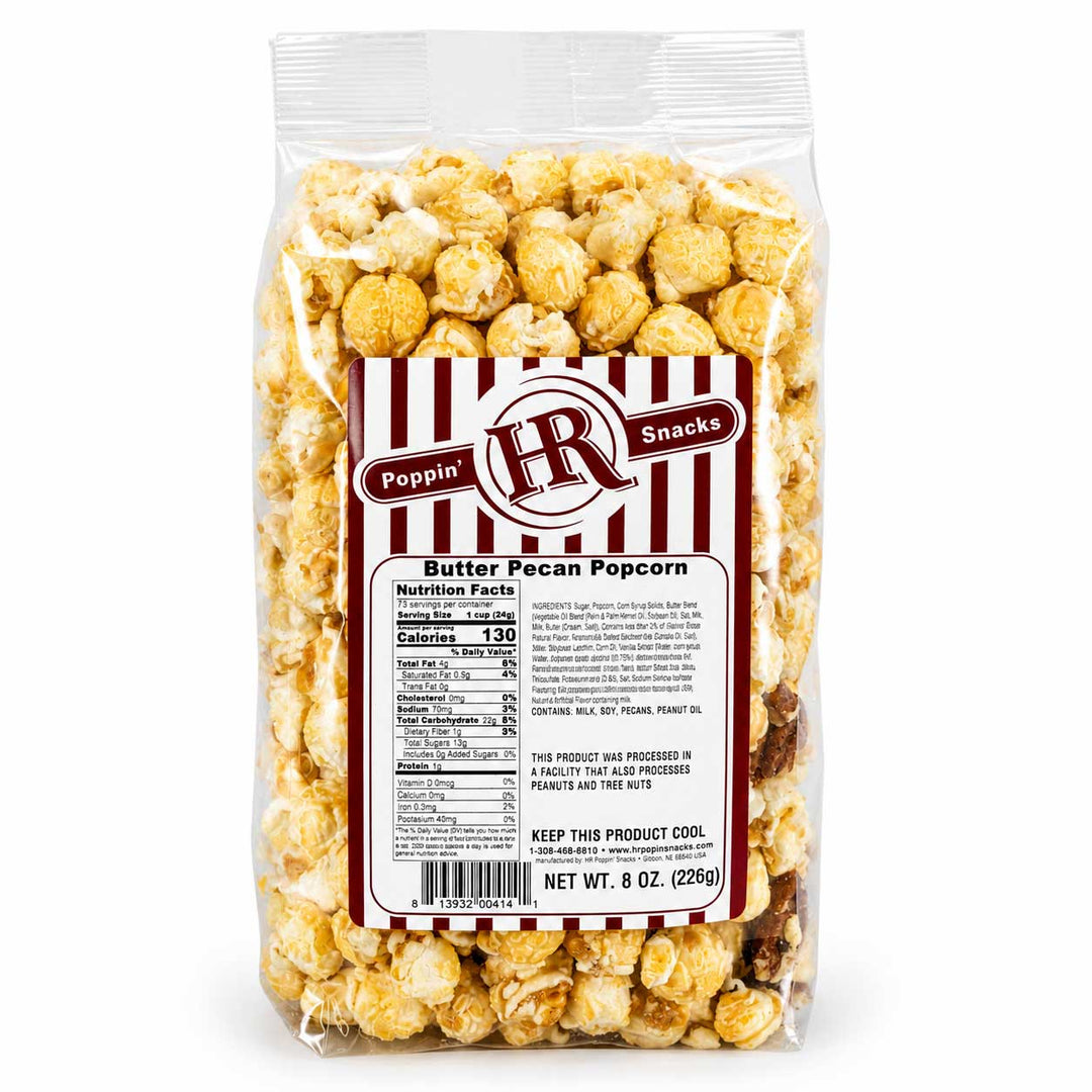 A 8 oz bag of Poppin' HR Snacks Butter Pecan Popcorn, showing the clear plastic packaging filled with golden-brown caramel popcorn and a red and white striped label on a white background.