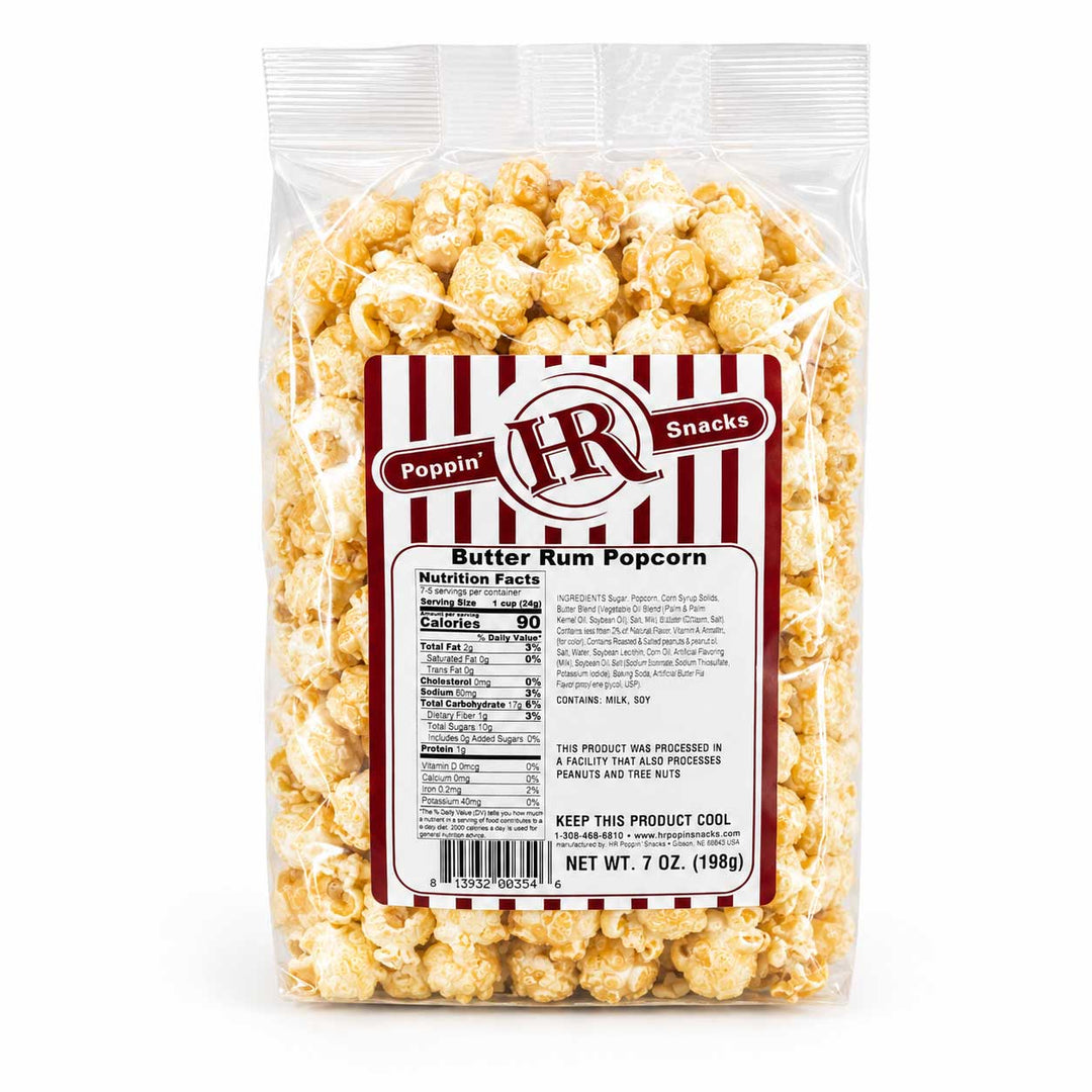 A 7 oz bag of Poppin' Butter Rum Popcorn on a clean white background. The clear plastic bag shows the golden, butter-coated popcorn inside, with a white and red striped label featuring the 'Poppin' IR Snacks' logo and nutritional facts.