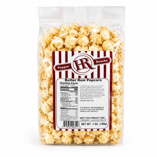 A 7 oz bag of Poppin' Butter Rum Popcorn on a clean white background. The clear plastic bag shows the golden, butter-coated popcorn inside, with a white and red striped label featuring the 'Poppin' IR Snacks' logo and nutritional facts.