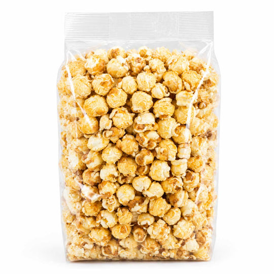 A clear plastic resealable bag filled with caramel popcorn on a plain white background.
