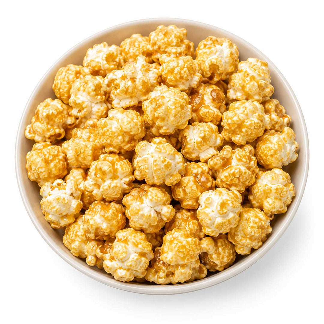 Caramel popcorn in a light beige bowl on a white background.
