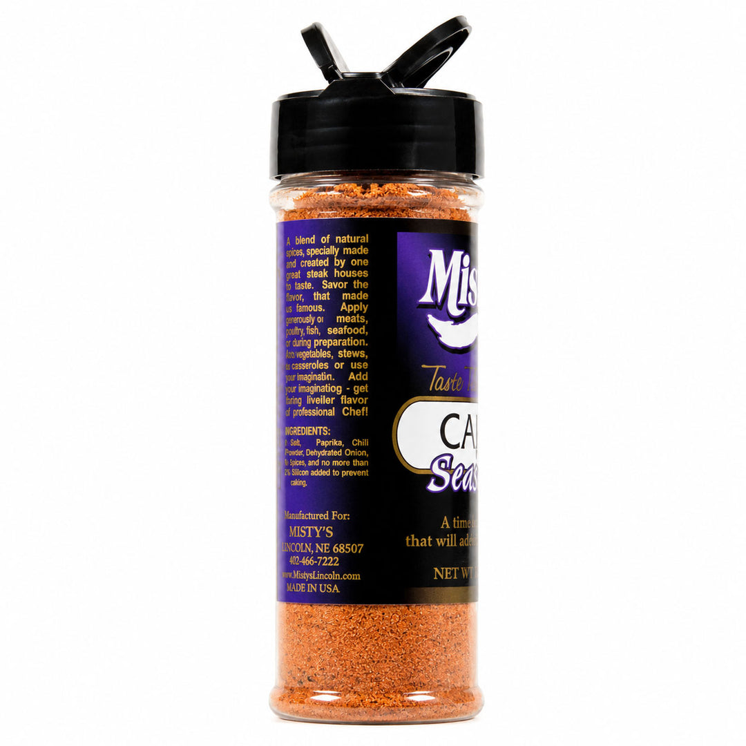 Spice container with black lid and orange spice mix on a white background
