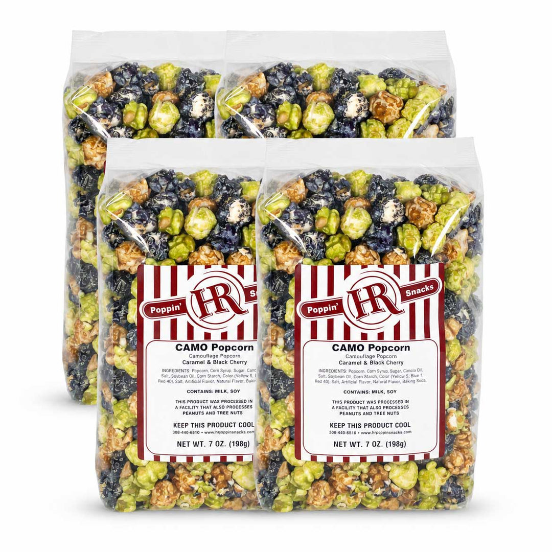 Three clear bags of Poppin' HR Camo Popcorn arranged in a studio setup on a white background. The bags contain mixed caramel and sea-salt flavored popcorn with green, beige, and dark blue-black pieces, and each bag has a red and white striped label.
