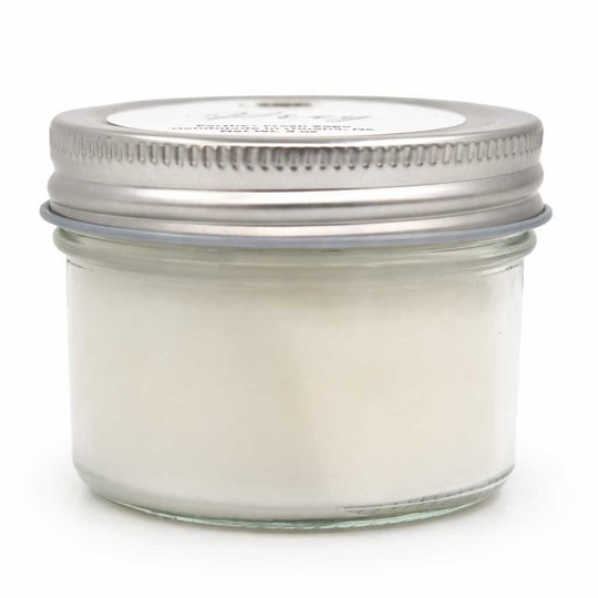 Glass jar with metal lid on a white background