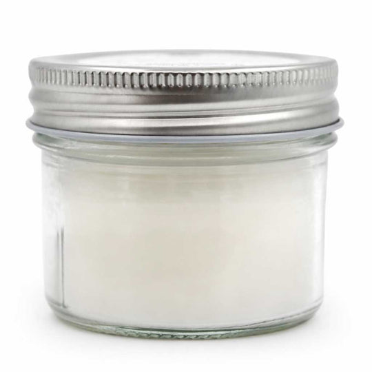 Clear glass jar with metal lid on a white background
