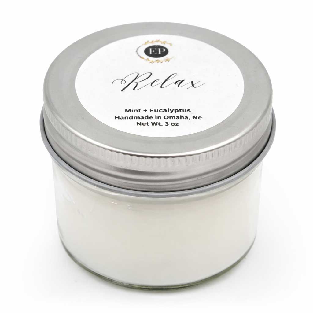 Candle jar with a silver lid labeled 'Relax' on a white background