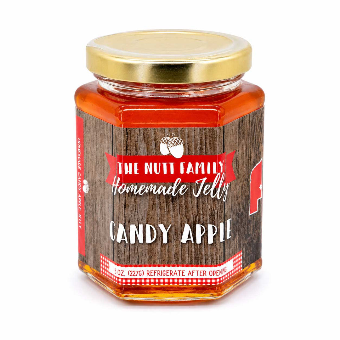 Jar of candy apple jelly with a wooden label on a white background
