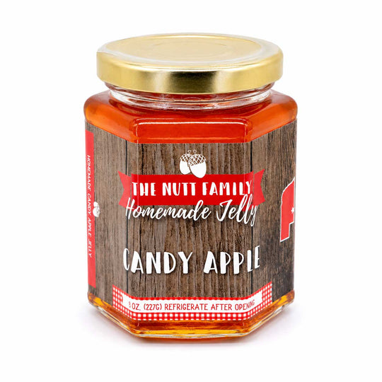 Jar of candy apple jelly with a wooden label on a white background