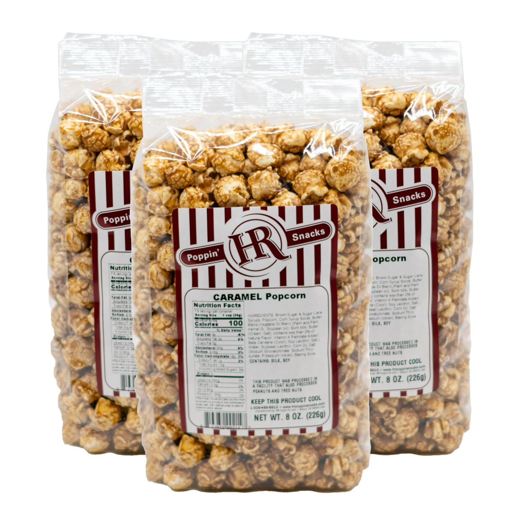 Three bags of Poppin' Corn caramel popcorn with visible labels on a white background