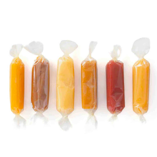 Row of wrapped candies in various colors on a white background