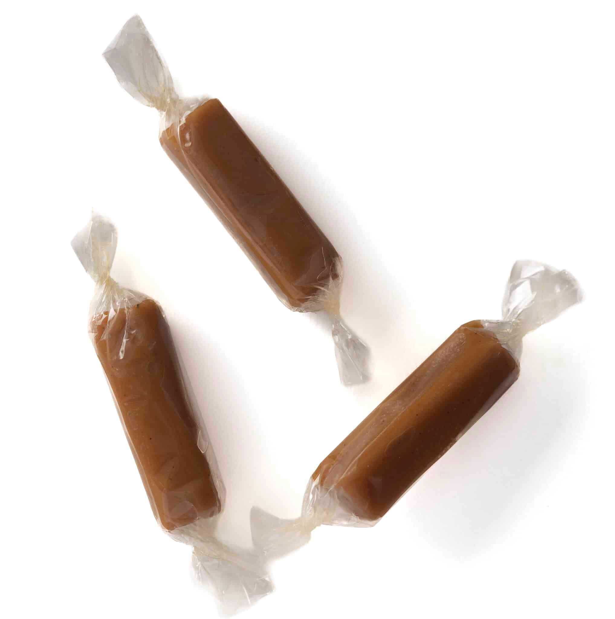 Three wrapped caramels on a white background