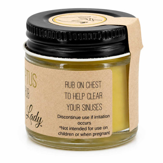 Jar of balm with a black lid and brown label on a white background