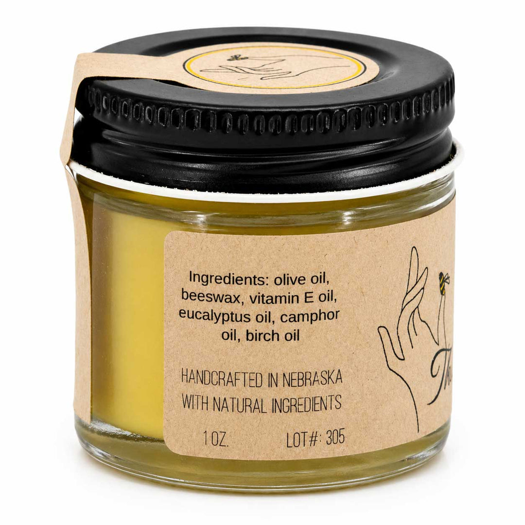 Jar of balm with black lid and brown label on a white background