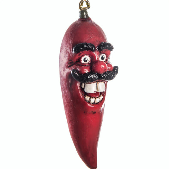Red pepper-shaped ornament with a face on a white background