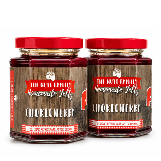 Two jars of The Nutt Family Homemade Jelly with red lids on a white background