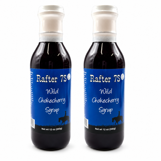 Two bottles of Rafter 7S Wild Chokecherry Syrup on a white background