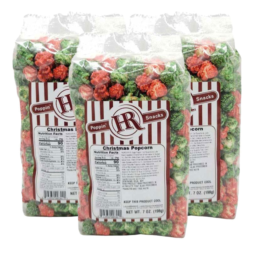 Three bags of Poppin' Hot Christmas popcorn with labels on a white background
