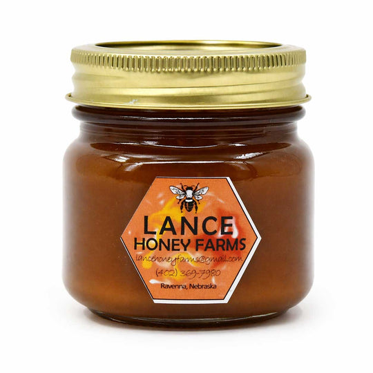 Jar of Lance Honey Farms honey with a gold lid on a white background