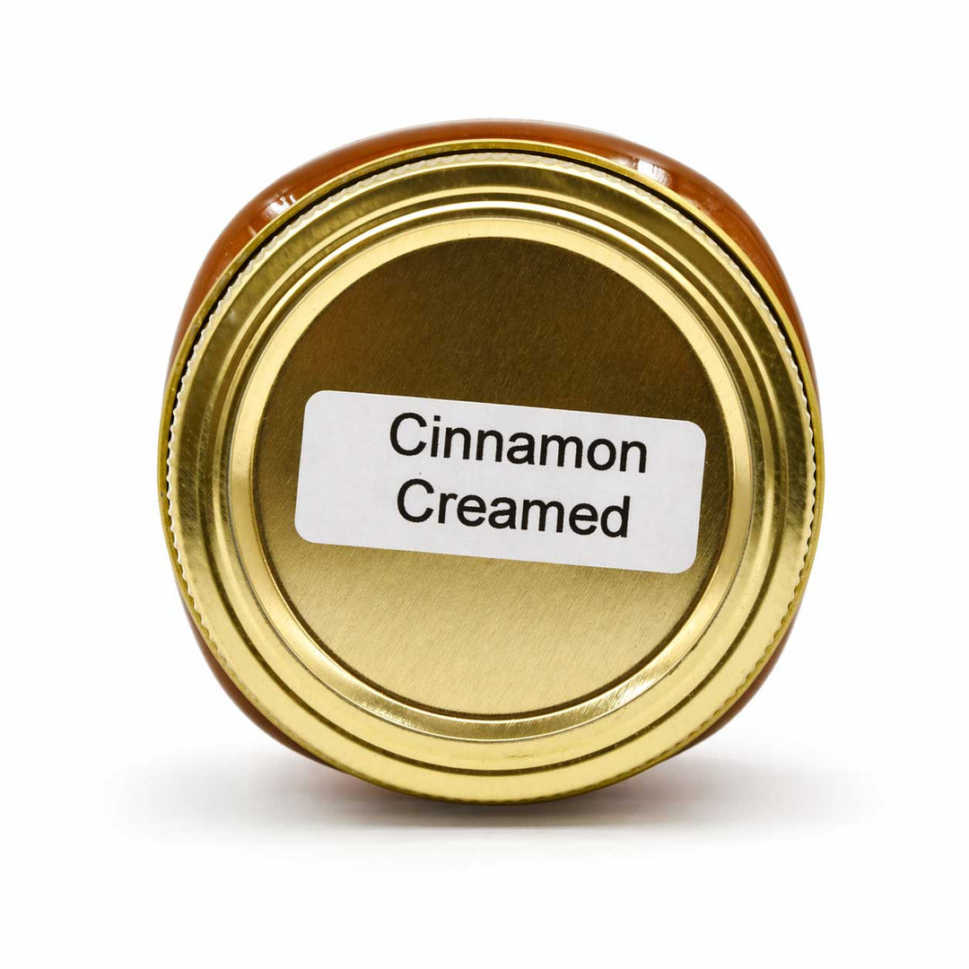 Gold jar lid with 'Cinnamon Creamed' label on a white background