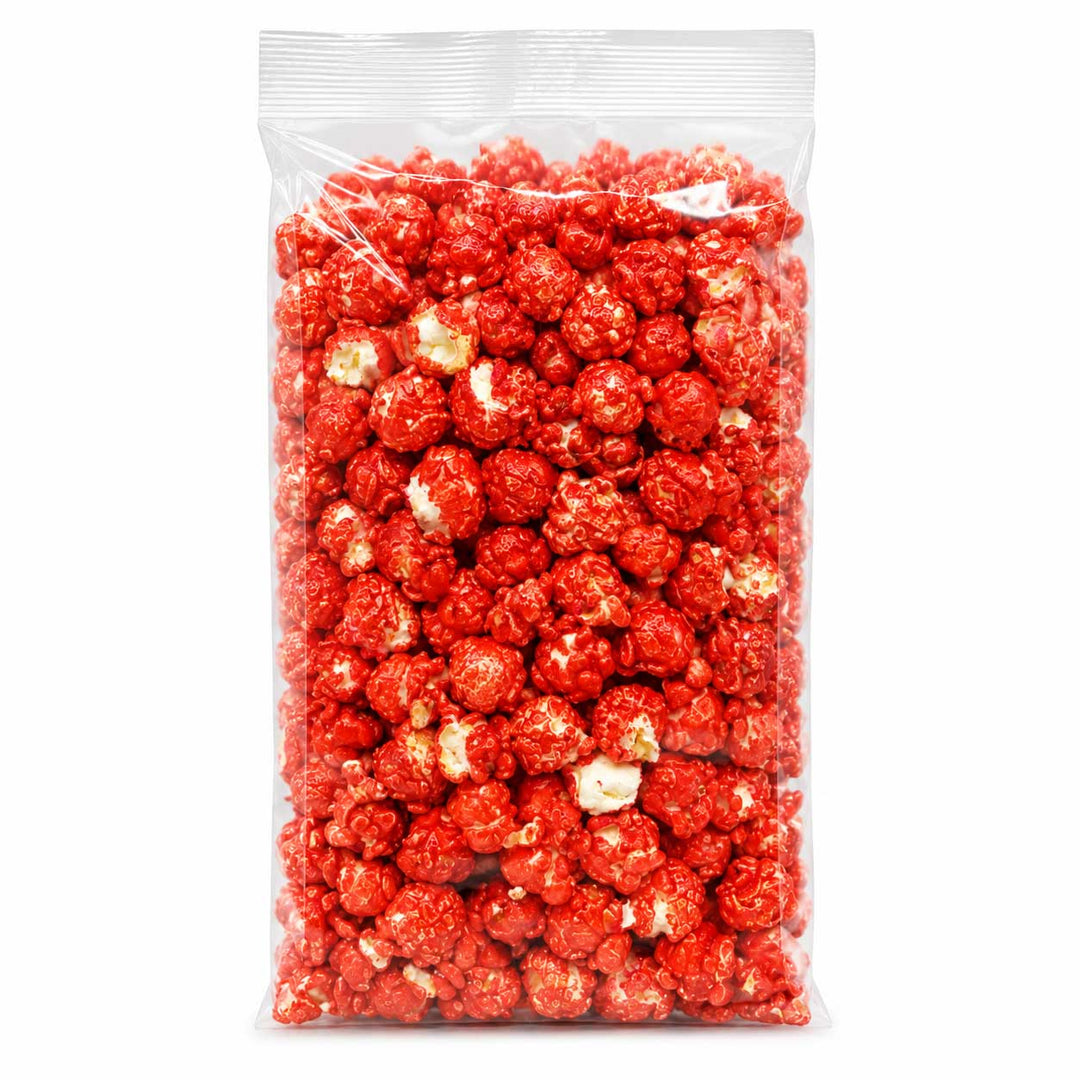 A clear plastic bag filled with bright red popcorn on a plain white background.