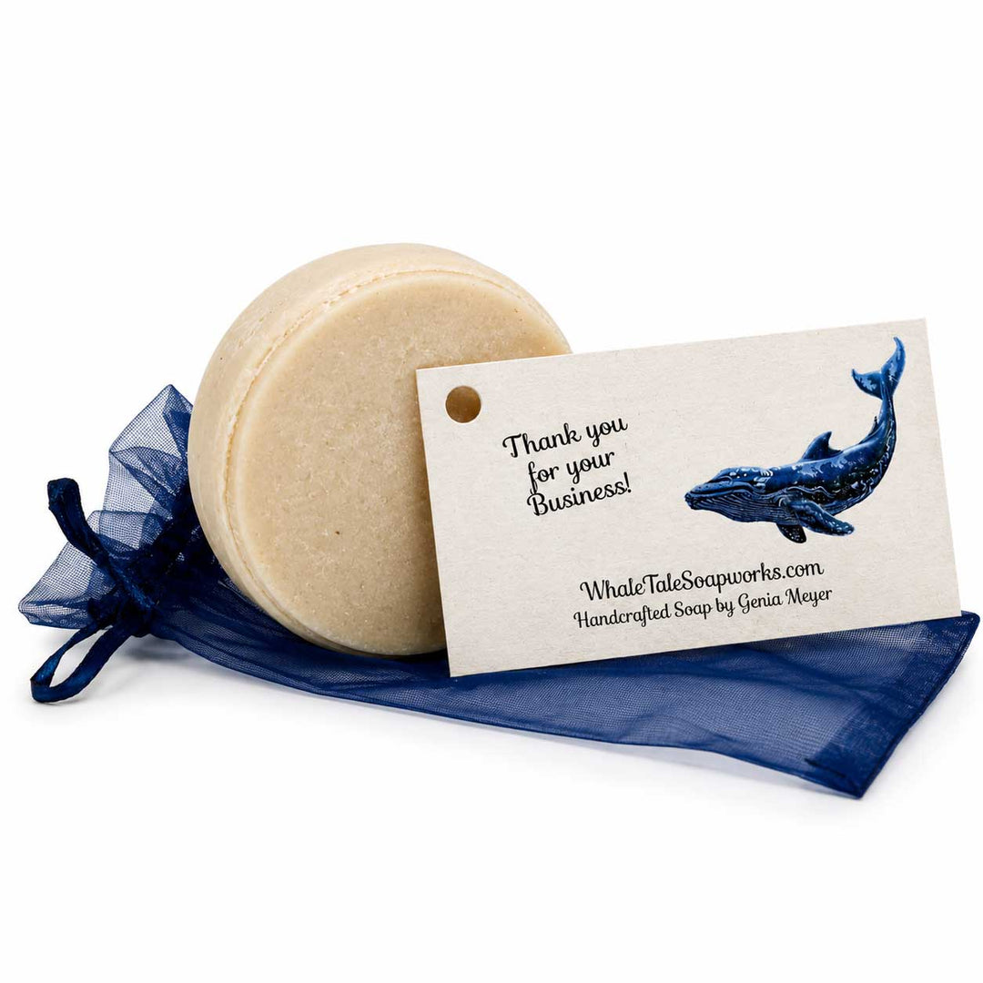 Bar of soap with a business card featuring a whale illustration on a white background