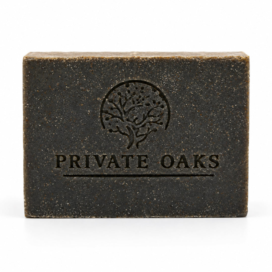 A rectangular dark brown bar of soap with a textured finish, embossed with a tree logo and the brand name 'PRIVATE OAKS' on the front, set against a plain white background.