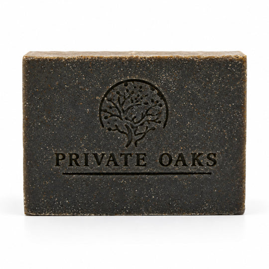 A rectangular dark brown bar of soap with a textured finish, embossed with a tree logo and the brand name 'PRIVATE OAKS' on the front, set against a plain white background.
