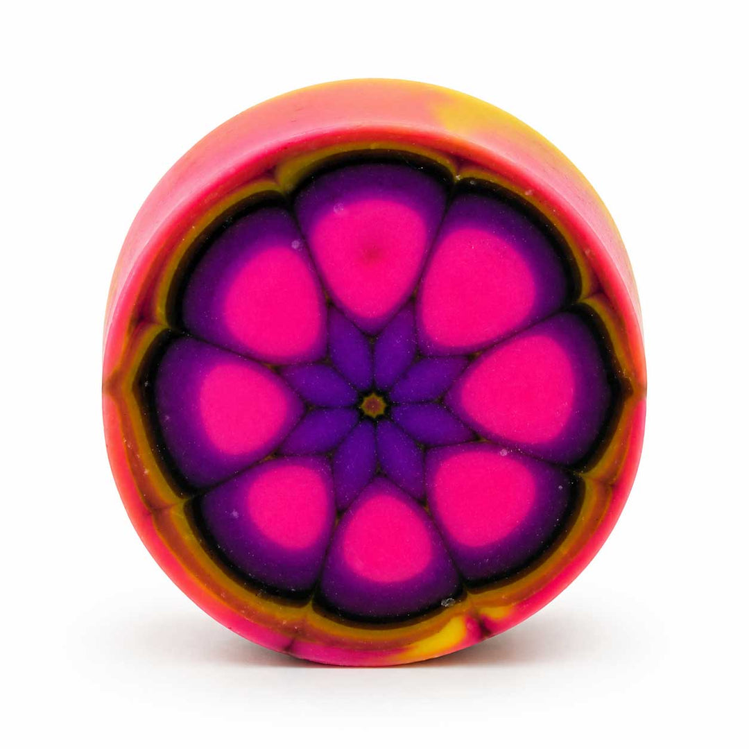 Colorful circular object with a pink and purple flower-like pattern on a white background
