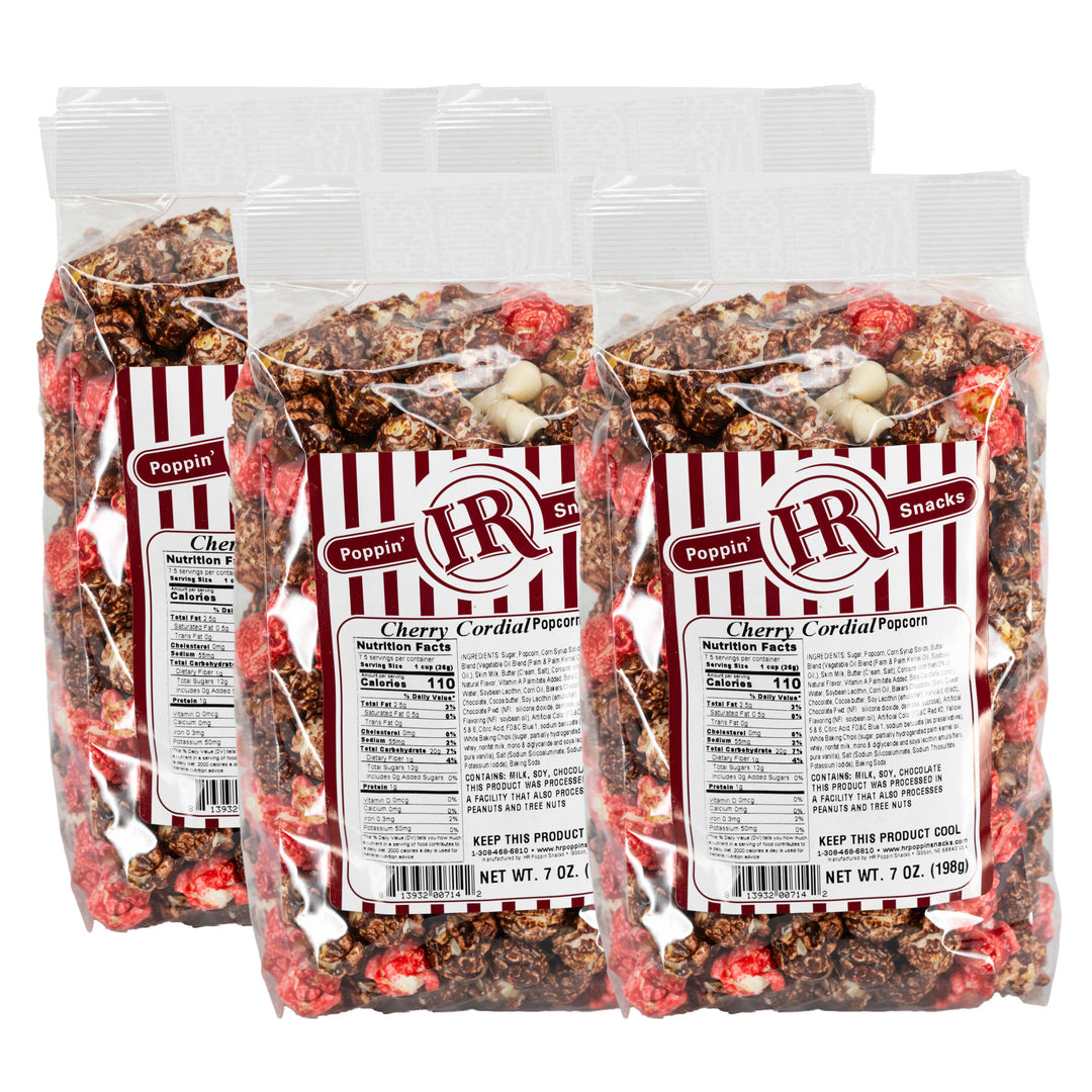 Four packages of Cherry Cordial Popcorn with visible branding and nutritional information.
