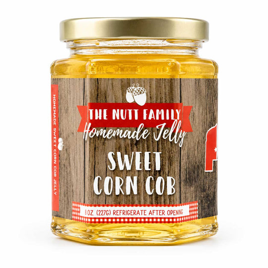 Jar of 'The Nutt Family' Sweet Corn Cob jelly with a wooden label on a white background