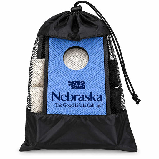 A black drawstring storage bag with mesh sides, featuring a blue Nebraska Cornhuskers themed insert panel with a circular cutout and rolled white corn in the side pockets, shown on a white background.