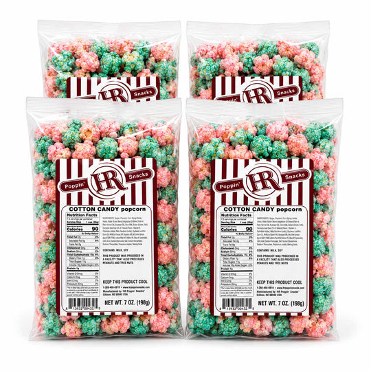 Four clear plastic bags of Poppin' Snacks Cotton Candy Popcorn arranged in a 2x2 grid on a white background. Each bag contains 7 oz (200g) of popcorn coated in pink and green candy, with a red and white striped label featuring the brand logo.