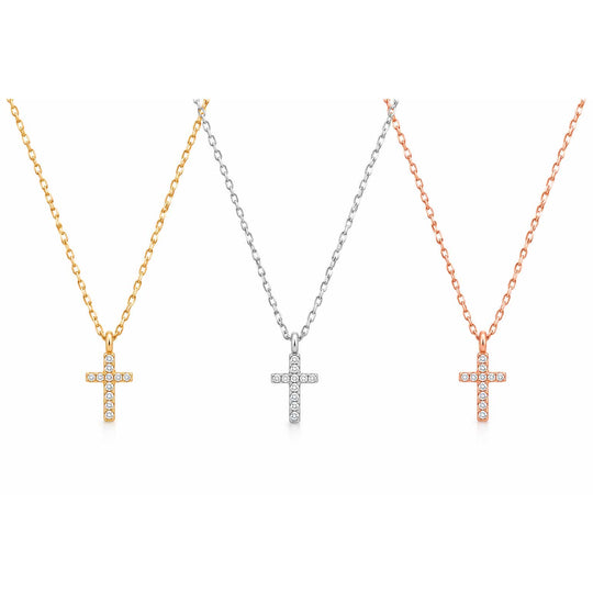 Three cross pendant necklaces on chains, shown side by side in yellow gold, silver, and rose gold tones. Each cross is adorned with small clear stones, set against a plain white background.