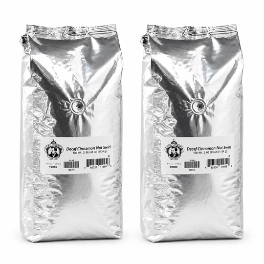 Two packages of Decaf Cinnamon Nut Swirl coffee on a white background