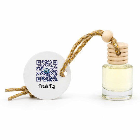Small perfume bottle with wooden cap and ceramic sphere featuring QR code and 'Fresh Fig' text on a white background