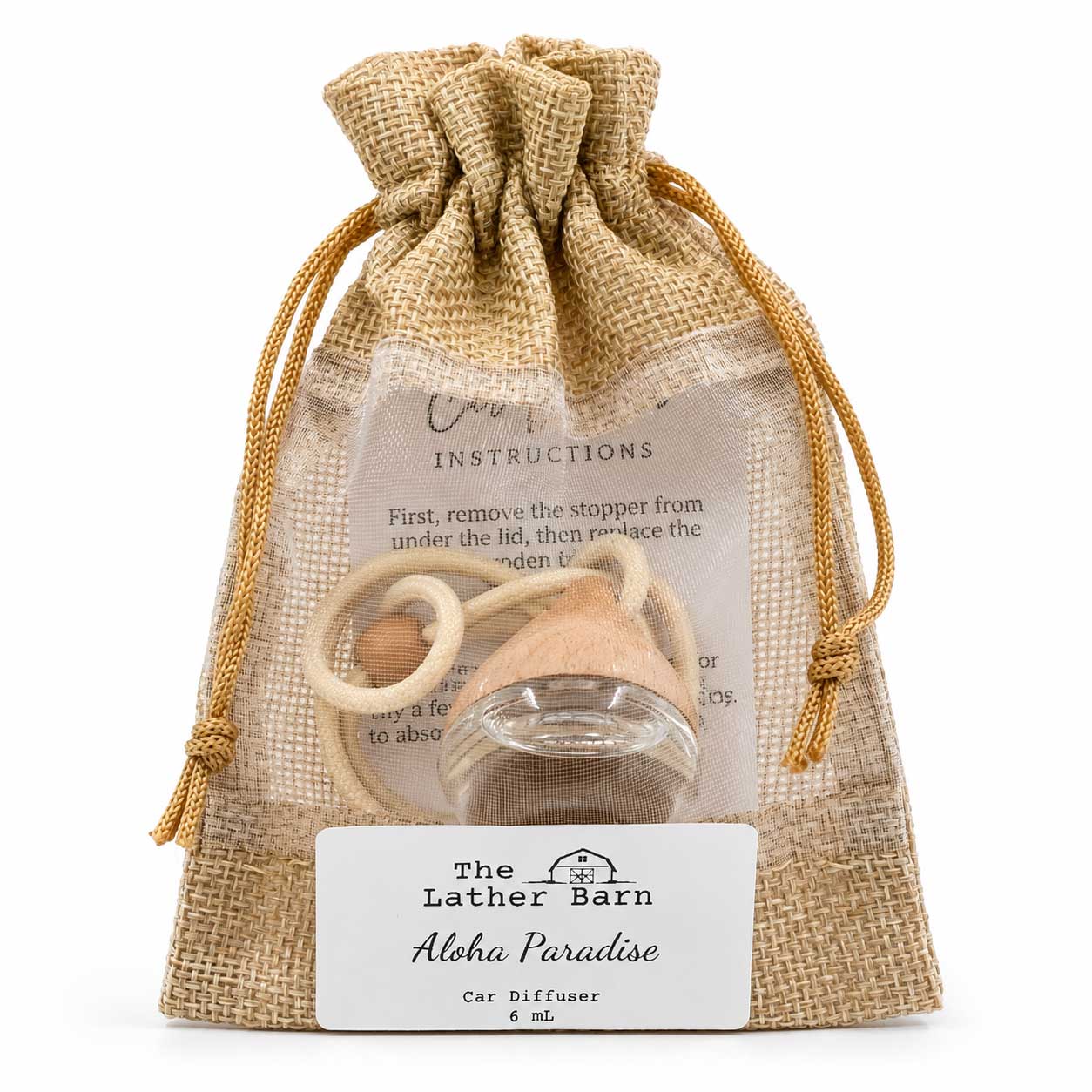A car diffuser gift set in a natural burlap drawstring pouch, containing a small glass bottle, wooden stopper, and wooden ring, with a white label reading 'The Lather Barn Aloha Paradise Car Diffuser 6 mL'.