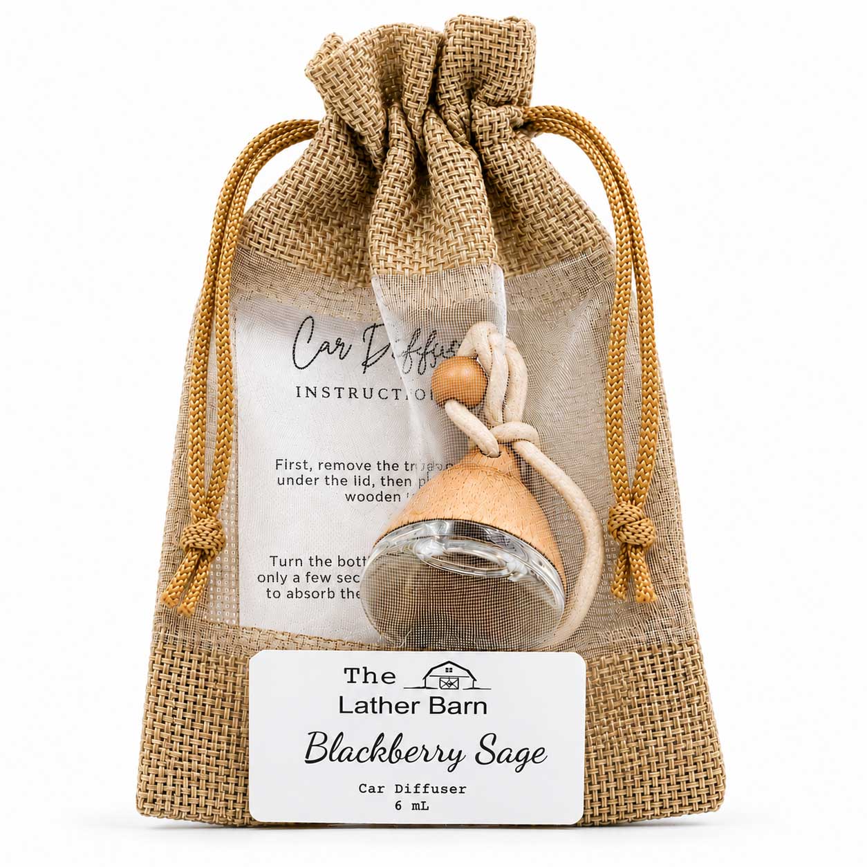 A small car diffuser in a clear glass bottle with a blackberry sage scent, packaged inside a natural burlap drawstring pouch. The pouch features a white label with instructions and the brand name 'The Lather Barn'.