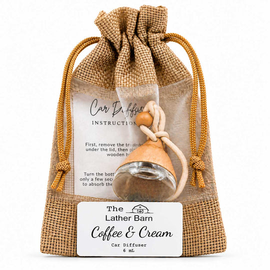 A small car diffuser gift set in a burlap drawstring pouch with a clear front window. Inside is a clear glass diffuser bottle with a light wood cap and a beige cord, plus printed instruction cards and a front label reading 'The Lather Barn Coffee & Cream Car Diffuser 6 mL.