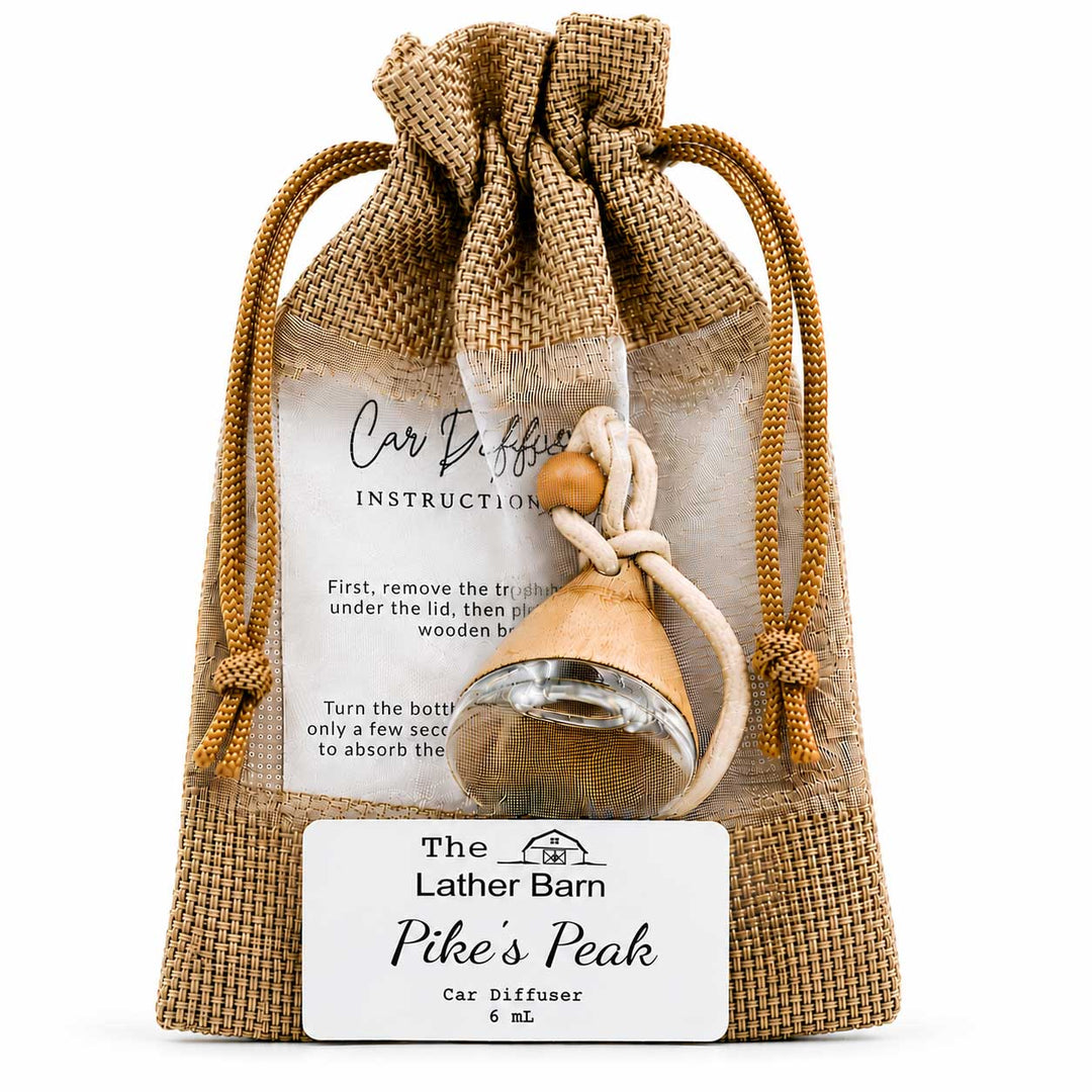 A packaged car diffuser set from The Lather Barn named Pike's Peak, featuring a small wooden diffuser bottle inside a clear bag with a burlap drawstring pouch and a white instruction card.